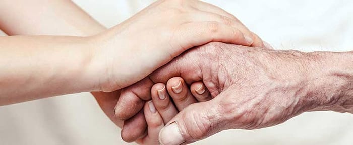 Caregiver holding hands with elderly client